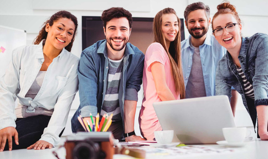 Un equipo de empresarios reunido en una mesa de trabajo, analizando estrategias con gráficos y laptops.