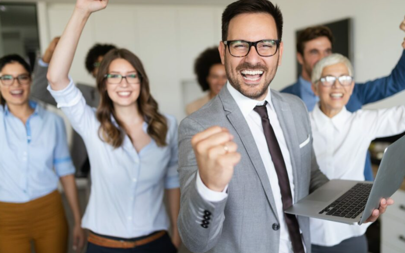 Un emprendedor dando una charla en un evento empresarial, rodeado de una audiencia comprometida.